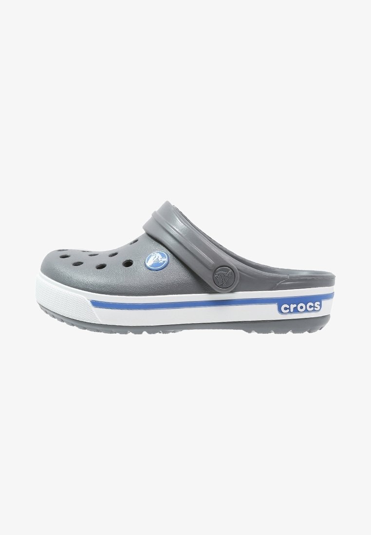 Sabot Crocs gris avec semelle blanche et bleue, trous de ventilation sur le dessus et bride de talon ajustable avec logos circulaires.