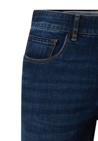 Donkerdenim jeans met een gladde textuur, voorzien van een voorzak, een zichtbare tailleband en contrasterende gele stiksels.