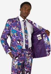 Fialový oblek so živými vzormi postáv Pokémon; zladená kravata. Interiér má jednofarebnú fialovú podšívku a značkovú etiketu. Strih prispôsobený postave.