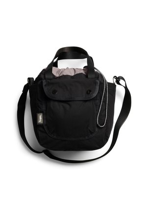 Kompakte schwarze Schultertasche mit Frontklappe, doppelten Griffen, verstellbarem Träger und Kordelzugverschluss, der helles Innenfutter zeigt.