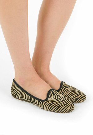 Pantofole piatte con motivo zebra e bordo nero, realizzate in morbido tessuto, dotate di punta arrotondata e suola flessibile per garantire il massimo comfort.