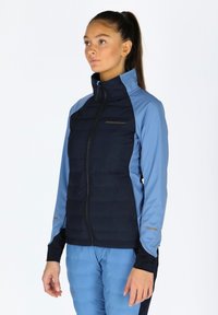 Navy and light blue jacket with zippered closure, padded body, and contrasting sleeves. Features a logo on the chest and cuff accents.