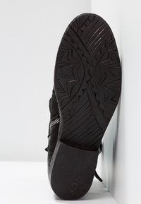 Svart sulan på en sko med texturerat gummi för grepp, zigzagmönster och en rundad form med storleksmärkningen 37.