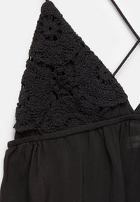 Abito nero con corpetto rifinito in pizzo con motivi floreali, vita elastica e spalline sottili regolabili. Tessuto morbido e trasparente.