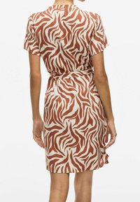 Kortärmad klänning i mjukt tyg med ett röd- och vitrandigt zebramönster, med ett knytbälte i midjan och en avslappnad passform.