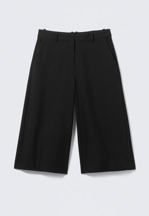 Zwarte op maat gemaakte knielange shorts met riemlussen en zijzakken op een effen lichte achtergrond.