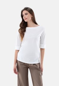 Weißes, leichtes Baumwollhemd mit Dreiviertelärmeln und aufgerollten Manschetten, ausgestattet mit einem weiten Rundhalsausschnitt, halbloser Passform und glatter Textur.