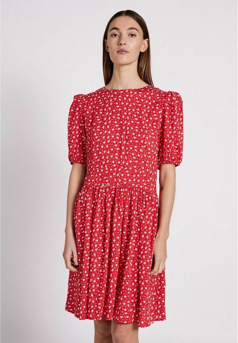 Rotes Blumenkleid mit kurzen Puffärmeln, rundem Ausschnitt, gerafftem Taillenbund und einem fließenden Rock. Mit einem kleinen weißen Blumenmuster.
