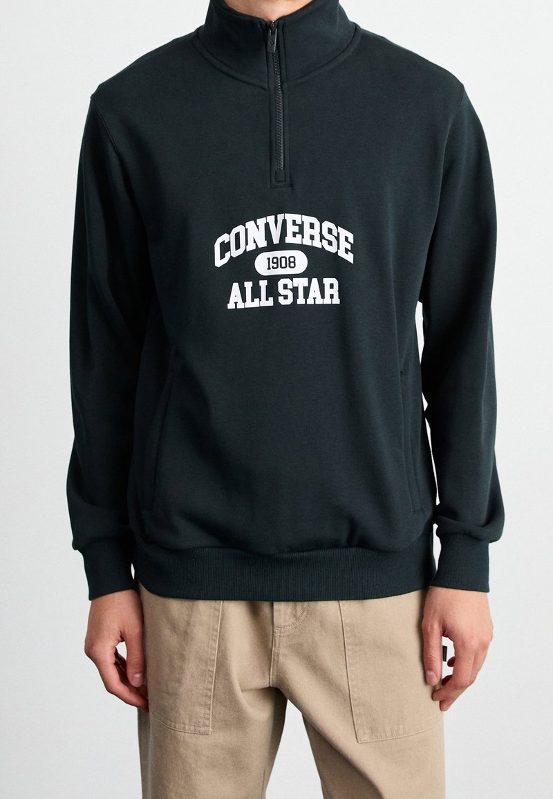 Donkergroene pullover sweatshirt met een ritskraag, voorzien van een witte "Converse All Star" graphic en geribbelde manchetten en zoom.