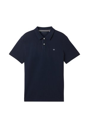 Mornarčasto plava polo majica od mekog pamuka. Ima tri dugmeta na kopčanju i mali logo na lijevoj strani prsnog koša. Kratki rukavi s klasičnim krojem.
