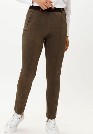 Bruna mönstrade byxor med slim fit, som har en hög midja och dragkedjefickor, i kombination med vita sneakers.