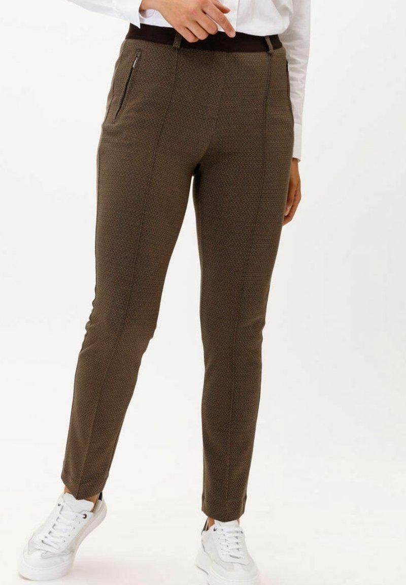 Bruna mönstrade byxor med slim fit, som har en hög midja och dragkedjefickor, i kombination med vita sneakers.