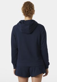 Sudadera con capucha azul marino con un acabado texturizado, mangas raglán y una cinturilla ajustada, combinada con pantalones cortos a juego.