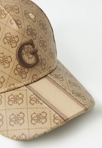 Rudas raštuotas beisbolo kepurė su ryškiu iškilniu "G" logotipu, plokščiu kupolu ir tekstūruotu paviršiumi su juostelės akcentu priekyje.
