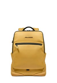 Mochila amarilla hecha de material liso y duradero; cuenta con un bolsillo frontal con cremallera, correas acolchadas y un asa superior. Detalles en negro adornan el diseño.