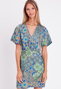 Abito a maniche corte in tessuto blu con intricate fantasie floreali e geometriche in verde e arancione. Design a V, silhouette aderente.