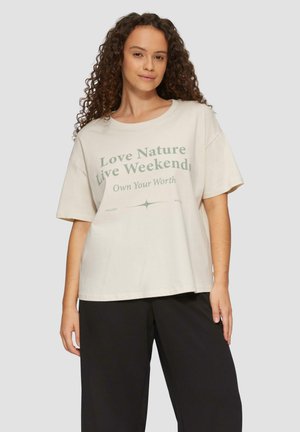 Korte mouwen, lichtbeige t-shirt met groene tekst "Hou van de Natuur Leef in het Weekend" en "Eigenschaat". Boxy fit en zachte textuur.