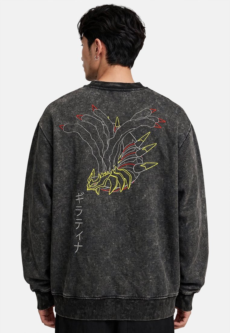 Homme portant un sweat-shirt noir délavé avec un motif multicolore de dragon stylisé et un texte japonais vertical dans le dos.