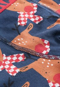 Material de bumbac cu un fundal bleumarin, decorat cu reni portocalii și eșarfe în carouri roșii, evidențiat de puncte albe și detalii de cusătură.