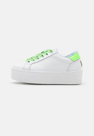 Basket à plateforme blanche avec œillets et languette de talon vert néon, tige en cuir lisse et semelle épaisse texturée vue de côté.