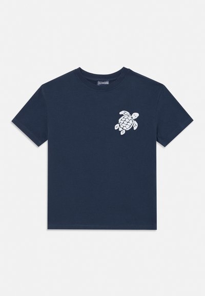 T-shirt blu navy a maniche corte con girocollo con una piccola grafica bianca di una tartaruga sul lato sinistro del petto.