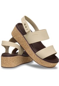Sandalias de plataforma beige con dos correas amplias y suaves; suela de cuña de corcho; plantilla marrón texturizada; sutil logotipo de la marca en un lado.