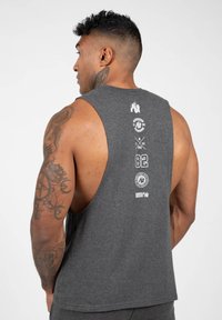 Heren donkergrijs mouwloos shirt, gemaakt van katoen, met witte graphics en logo's op de achterkant. Soepele textuur, relaxed fit ontwerp.
