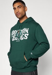 Felpa verde in misto cotone, con un grande motivo bianco "BOSTON CELTICS", tasca a canguro e cappuccio regolabile con cordino.