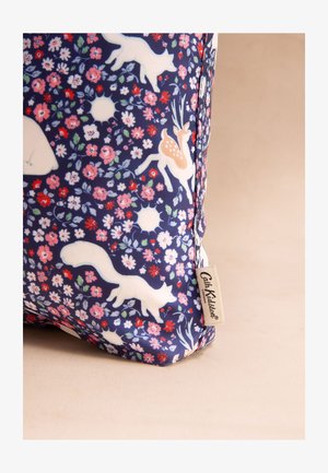 Ciemnoniebieska tkanina z białymi sylwetkami zwierząt, w tym lisa, jelenia i niedźwiedzia, otoczona różowymi i czerwonymi wzorami kwiatowymi oraz małą metką marki.