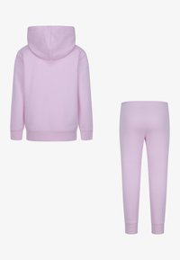 Felpa rosa chiaro con cappuccio regolabile e polsini a coste, abbinata a pantaloni della tuta slim-fit con vita elastica.