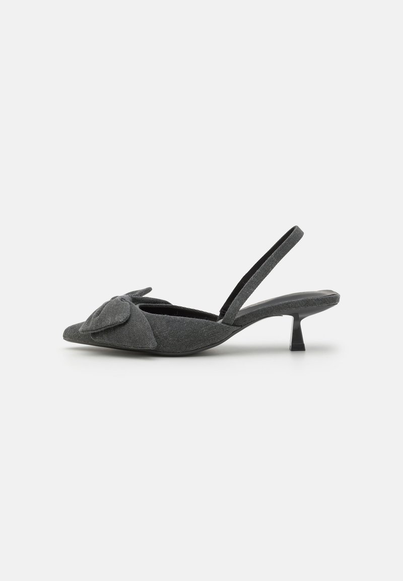 Szürke anyagú, slingback sarokcipő hegyes orral, amelyen egy masni díszítés található a lábfejnél, és rövid stiletto sarkú. Sima textúra, minimalista design.
