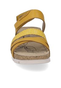 Geel sandaal met drie brede banden, waaronder een gevlochten band, een gevoerde voetbed en een witte zool. Getextureerde binnenvoering zichtbaar.