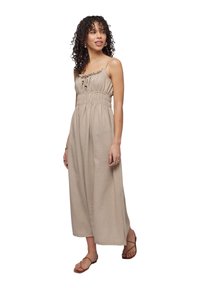 Abito maxi beige con spalline regolabili, scollatura a volant e vita arricciata. Tessuto leggero con una consistenza morbida.