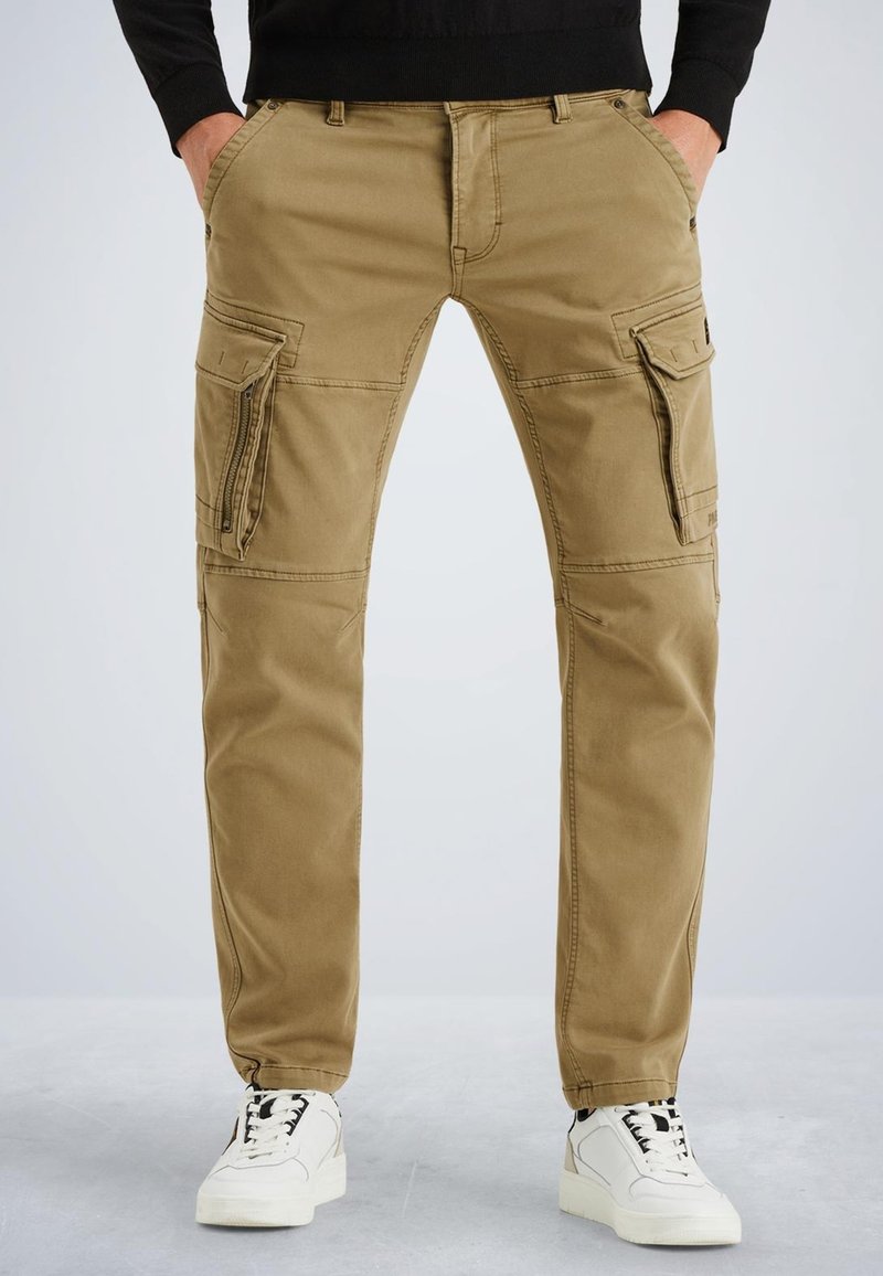 Pantalons cargo beiges avec plusieurs poches latérales, coupe droite, tissu en coton durables, et détails de couture visibles, associés à des baskets blanches.