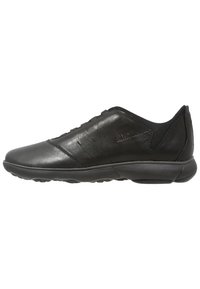 Sneaker din piele neagră, cu o textură netedă, profil jos, accente din plasă și talpă din cauciuc. Prezintă dungi subtile și brand pe lateral.