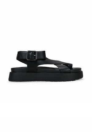 Sandalias de cuero negras con suela gruesa, con un diseño de tiras cruzadas, hebilla ajustable en el tobillo y plantilla texturizada para mayor comodidad.