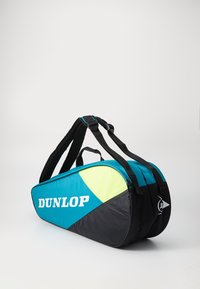 Dunlop Sporttasche mit türkisfarbenen, schwarzen und neon-gelben Elementen, gepolsterten Tragegurten und Logo auf der Seite gedruckt. Runde, schlanke Form.