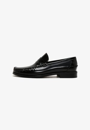 Zwarte leren loafers met een ronde neus, gestikte details langs de randen en een lage blokhak. Gladde textuur en minimalistisch ontwerp.