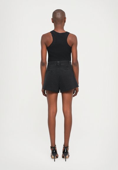 Black tank top and high-waisted black denim shorts, with a tailored fit. Smooth texture, minimal detailing, and matching black high heels.