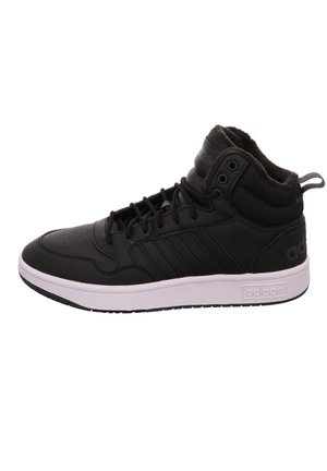 Basket montante noire Adidas avec semelle blanche, lacets sur le devant, col de cheville matelassé et trois bandes sur le côté.