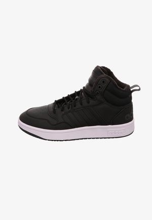 Basket montante noire Adidas avec semelle blanche, lacets sur le devant, col de cheville matelassé et trois bandes sur le côté.