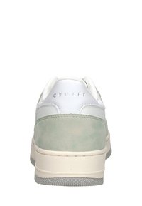 Cruyff sneakers met een witte leren bovenkant en een lichtgroene suède achterkant, een textuur rubberen zool en een minimalistisch ontwerp.