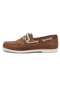 Bruine leren bootschoen met witte zool, voorzien van klassieke veters, metalen oogjes en gestikte details langs de randen.