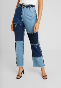 Högmidjade, patchwork-jeans i olika nyanser av blå denim, med fransade kanter och rak benform. Har framfickor och knappstängning.