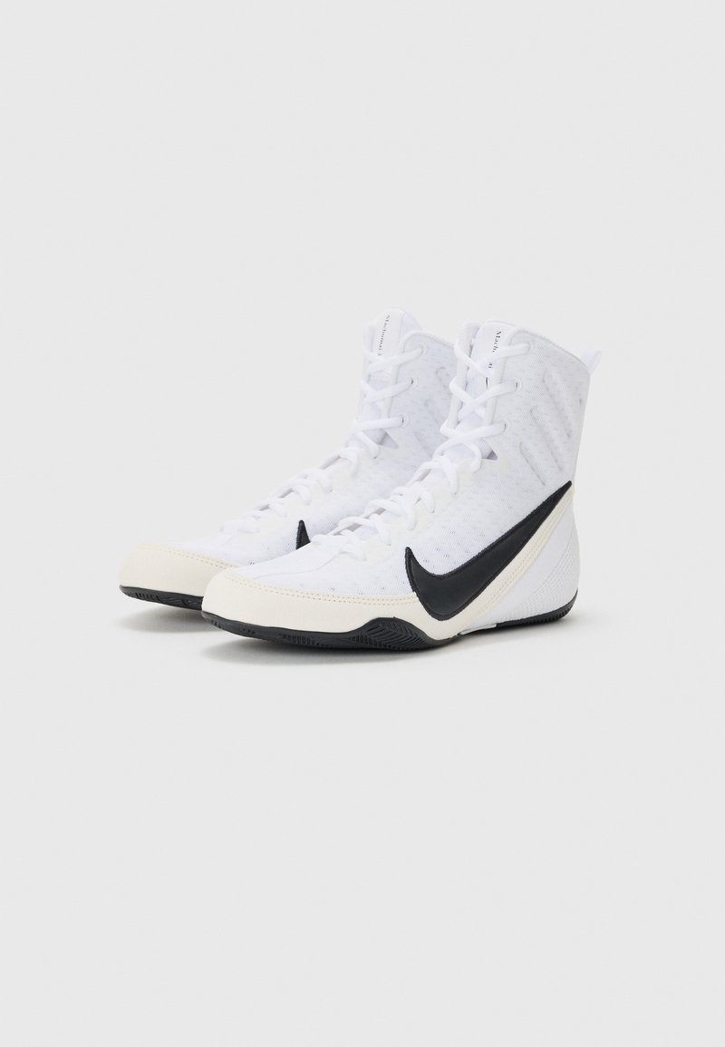 Witte sportieve schoenen met een hoge ontwerp, voorzien van een zwart Nike-swoosh, getextureerd mesh bovenwerk en rubberen zool met grippatroon.