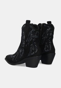 Botas de tobillo de ante negro con tacones bajos apilados, cremalleras laterales y patrones decorativos de rhinestones azules.