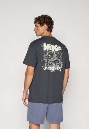 Gray cotton t-shirt featuring a large cream Nike logo and basketball graphic on the back. Short sleeves and a relaxed fit.