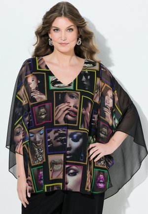 Naisella, jolla on laineikkaat hiukset, musta läpikuultava paita, jossa on värikkäitä kehyksiä lähikuvissa kasvoista ja huulista, poseeraa käsi lanteilla.