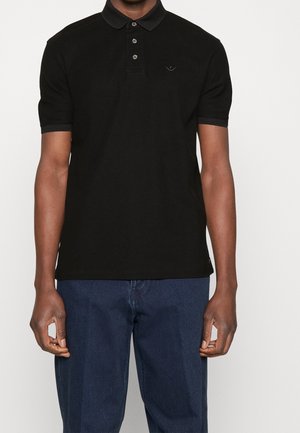 Polo nera con colletto, tre bottoni e maniche corte. Presenta un logo discreto sul petto e un tessuto testurizzato.