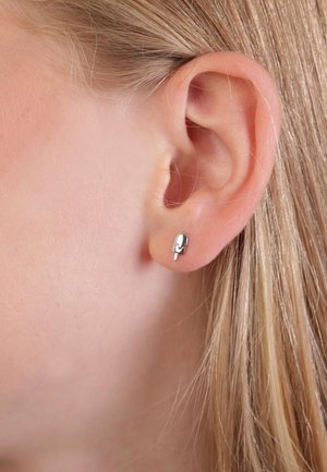 Silberne Ohrstecker in Form von Eis am Stiel, mit glänzender Oberfläche und glatter Textur, getragen in einer Ohrläppchen-Piercing.
